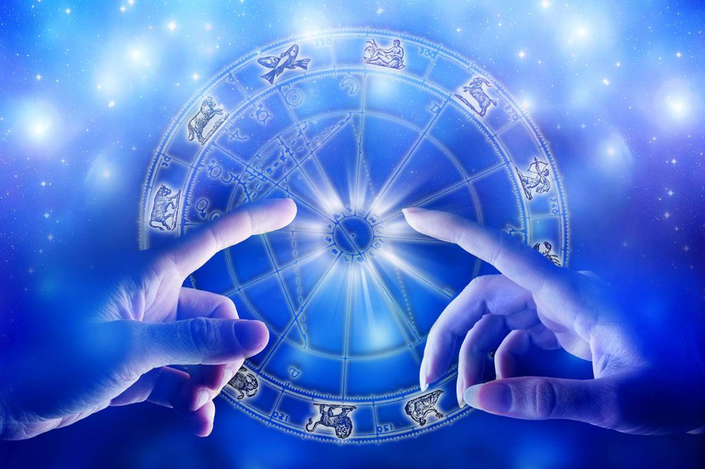 hands pointing to an astrology chart