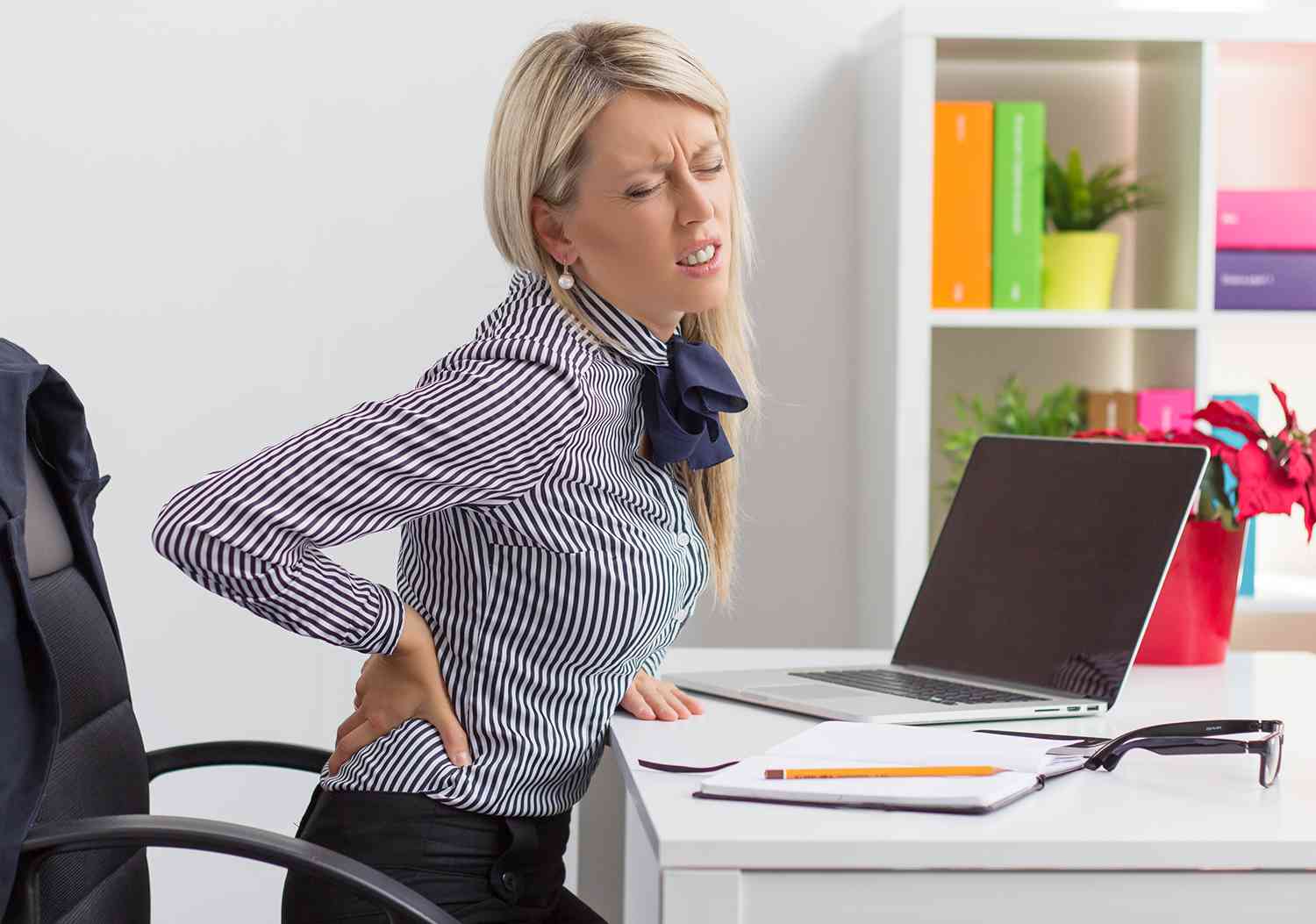 woman sitting at desk with backpain