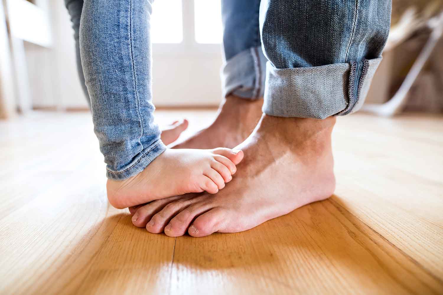 barefoot father and child at home